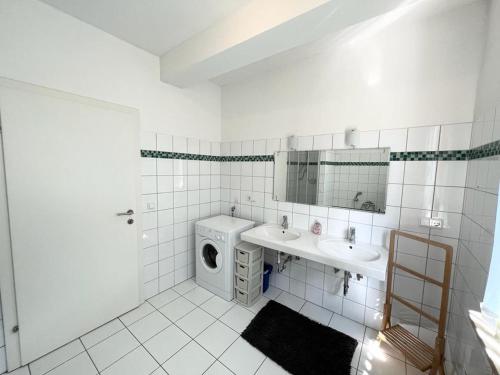 uma casa de banho com um lavatório e uma máquina de lavar roupa em Four Seasons Getaway - 3 minutes From Town Centre em Zell am See