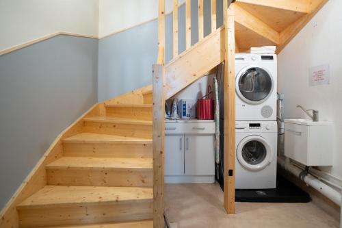 a staircase with a washer and dryer in a laundry room at Les Jardins De La Seugne in Jonzac
