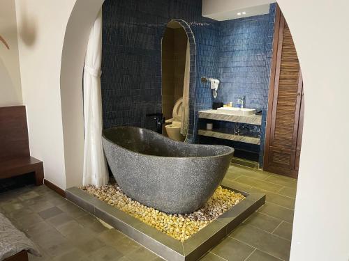a bathroom with a bath tub and a sink at TROPICAL HOUSE RIVERSIDE RETREAT in Thuan An