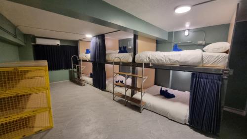 a room with three bunk beds in it at Glur Hostel Pattaya Walking Street in Pattaya