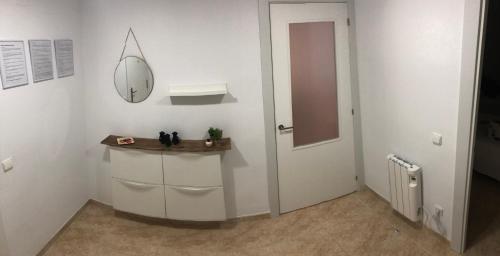 Cette chambre blanche dispose d'un miroir et d'un lavabo. dans l'établissement Apartamento SalouMar, à Salou