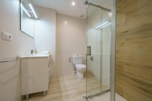 ein Bad mit einem WC und einer Glasdusche in der Unterkunft HomeHolidaysRentals Music - Costa Barcelona in Pineda de Mar