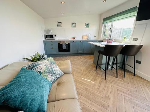 uma sala de estar com um sofá e uma cozinha em Hazells Lodge Farm Stay Sleeps 2 Hottub Pool Table at Ayrshire Rural Retreats em Galston