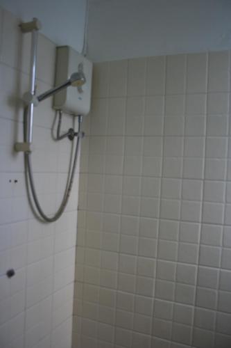 a shower in a bathroom with white tiles at 21LG Ilot Fortier M Sea Front and Swimming pool in Rivière Noire