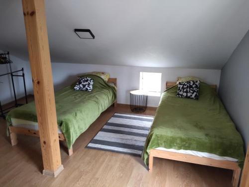 a bedroom with two twin beds and a rug at Apartamenty Dominik in Wiele