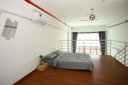 ein Schlafzimmer mit einem Bett und einem Balkon in der Unterkunft Private 100 inches Screen Cinema at CEO Penang in Bayan Lepas