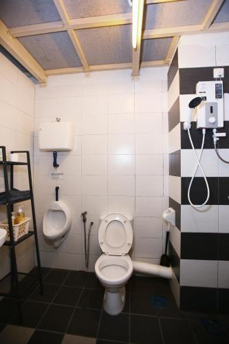 a bathroom with a toilet and a urinal and a sink at Private 100 inches Screen Cinema at CEO Penang in Bayan Lepas