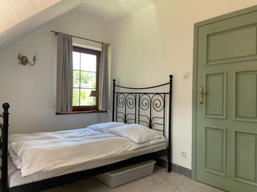 a bedroom with a bed and a green door at Zaciszne Apartamenty in Poddąbie