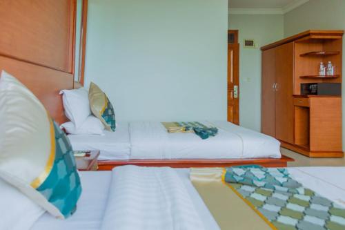 a bedroom with a large bed with white sheets at Greenlight Hotel in Dar es Salaam