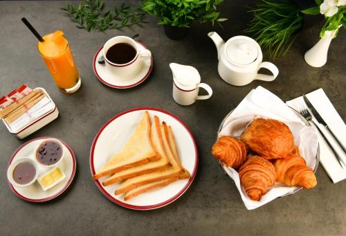 a table with plates of pastries and cups of coffee at Retaj Inn Al Wakrah in Al Wakrah