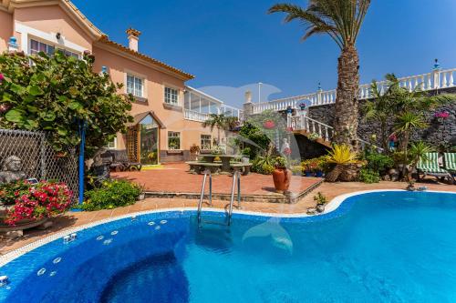 a swimming pool in front of a house at Apartamentos Los Delfines in El Médano