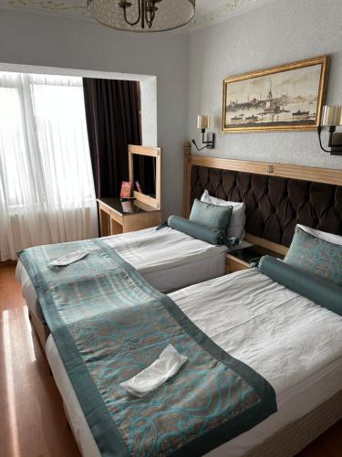 イスタンブールにあるブルー トゥアナ ホテルのベッド2台とテレビが備わるホテルルームです。