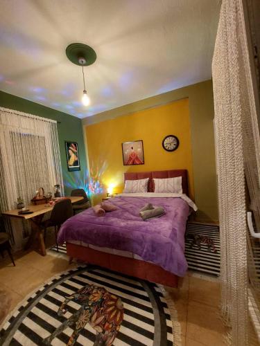 a bedroom with a purple bed and a desk at Φιλοξενία1 in Drama