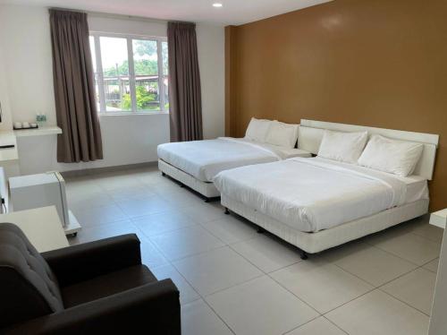 a hotel room with two beds and a couch at Melati Tanjong Beach Resort in Pantai Cenang