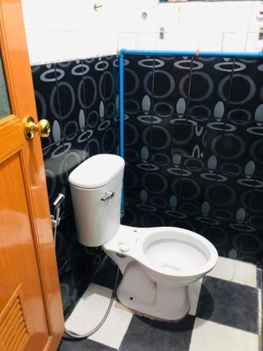 a bathroom with a toilet and a black and white tile floor at Yem Homestay in Baguio