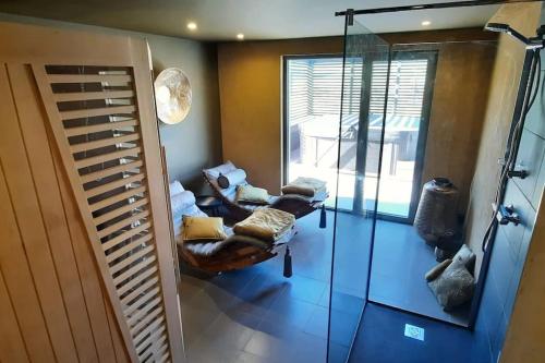 a living room with chairs and a glass door at Gîte "Villa Belle Vie" in Labaroche