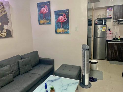 uma sala de estar com um sofá, uma mesa e um frigorífico em The Persimmon Condominium 1 bedroom Unit em Cebu