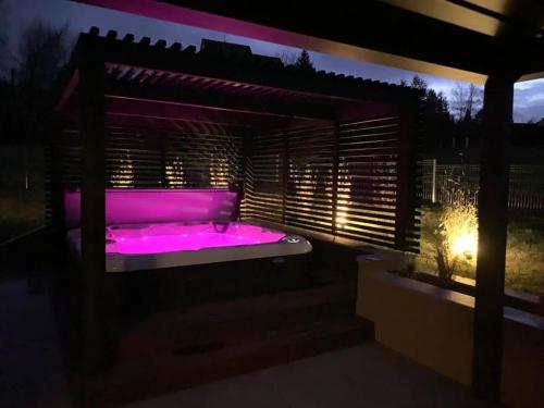 a purple hot tub in a backyard at night at Gîte "Villa Belle Vie" in Labaroche