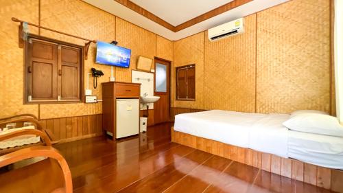 a bedroom with a bed and a tv in it at Baan Siriporn Resort - โรงแรมบ้านศิริพร รีสอร์ท in Samut Songkhram