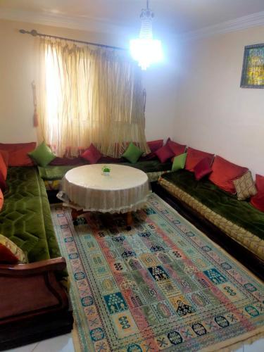 uma sala de estar com um sofá e uma mesa em Appartement à louer à Tadamon 2 Hay Salam / Agadir em Agadir