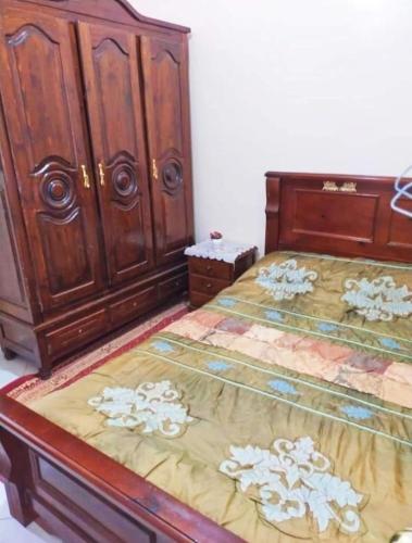 um quarto com uma cama e um armário de madeira em Appartement à louer à Tadamon 2 Hay Salam / Agadir em Agadir