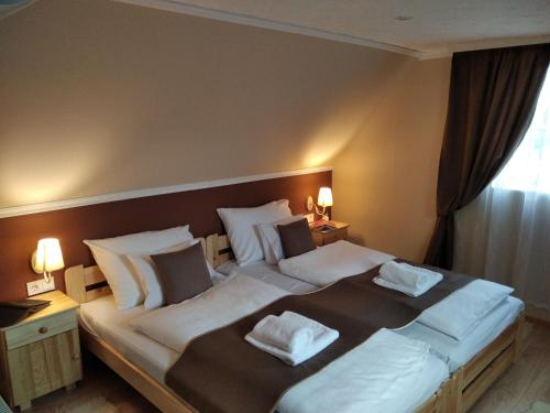1 dormitorio con 2 camas con almohadas blancas en Mözsi Apartman Tolna, en Tolna