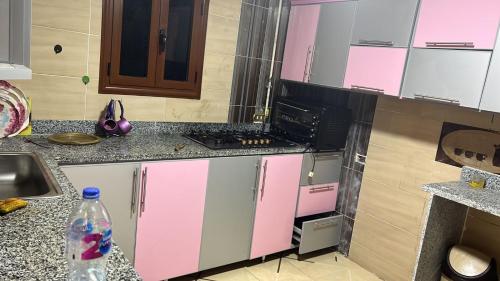 a kitchen with pink and white cabinets and a sink at 84 جسر السويس الدور 6 in Cairo