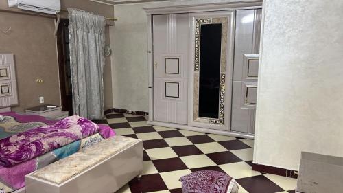 ein Schlafzimmer mit einem Bett und einem Schachbrettboden in der Unterkunft 84 جسر السويس الدور 6 in Kairo