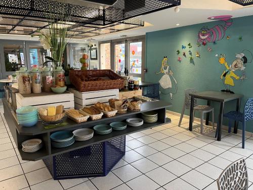a kitchen with a counter with bowls and plates on it at initial by balladins Tours Sud in Chambray-lès-Tours