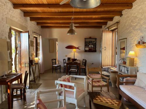 a living room with tables and chairs and a dining room at Villa LA FAMILIA maison traditionnelle in Plakias