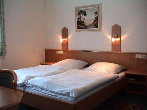 1 dormitorio con 2 camas y 2 luces en la pared en Hotel Garni Kreuzäcker, en Ulm