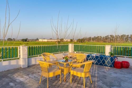 a patio with a table and chairs on a balcony at StayVista at Colour Bloom - 2 BR Pet Friendly Villa in Delhi Haryana with Swimming Pool in Bidauli