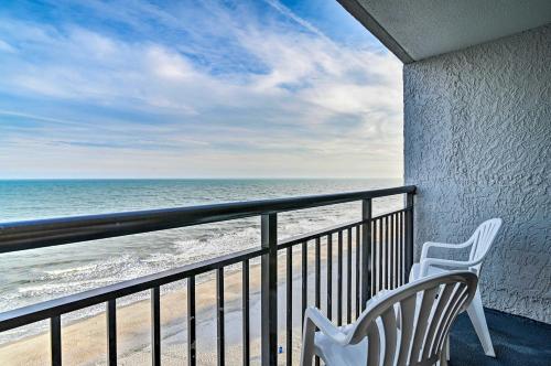 two white chairs sitting on a balcony overlooking the beach at Oceanfront Balcony Resort Condo in Myrtle Beach in Myrtle Beach