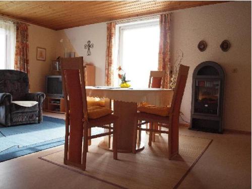 a living room with a table and chairs and a fireplace at Ferienwohnung Christa in Mauth