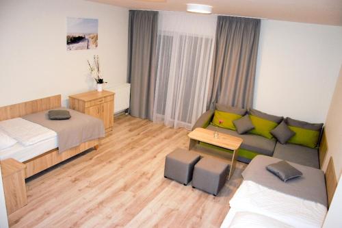 ein Zimmer mit einem Bett und einem Sofa und einem Bett sowie einem Wohnzimmer in der Unterkunft Dom Gościnny Matex in Pustkowo