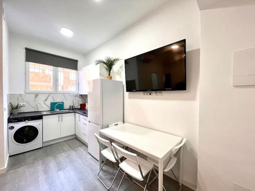 eine Küche mit einem weißen Tisch und einem weißen Kühlschrank in der Unterkunft Cool Space in Madrid