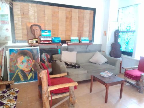 ein Wohnzimmer mit einem Sofa und einer Gitarre in der Unterkunft Ocean Way Guraidhoo in Guraidhoo