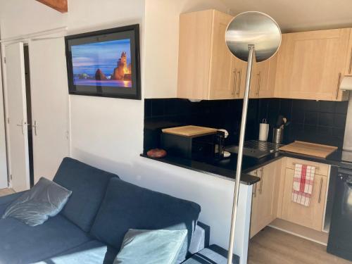 a living room with a couch and a kitchen at Charming 1 bedroom flat, Biarritz center with pool and car park in Biarritz