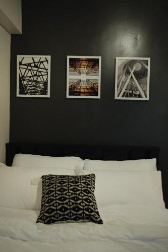 una camera da letto con tre immagini sul muro e un letto di Modern Minimalist 1 BR Condo in IT Park a Cebu City