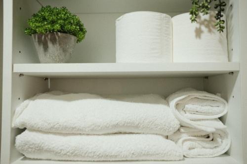 a shelf with towels and a plant on it at Modern Minimalist 1 BR Condo in IT Park in Cebu City