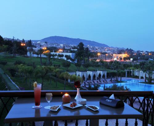a table with food and drinks on a balcony with a view at Palais Medina Riad Resort in Fès