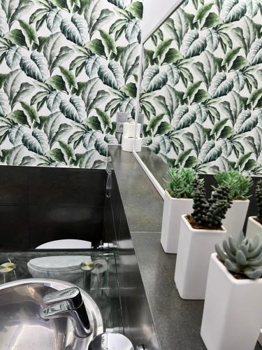 a bathroom with plants on the wall and a sink at Willa Jelitkowska in Gdańsk