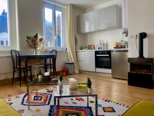 a living room with a table and a kitchen at Les mouettes de Trouville in Trouville-sur-Mer