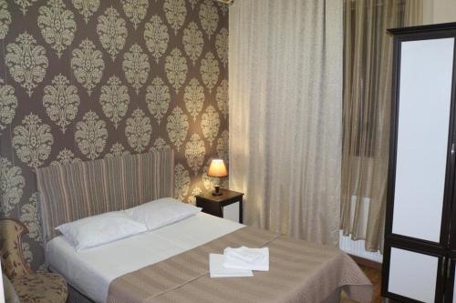 a bedroom with a bed with a table and a window at Hotel Albatros in Batumi