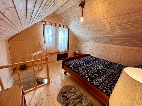 Habitación pequeña con cama en una habitación de madera en Chalet Nomad, en Petroşani