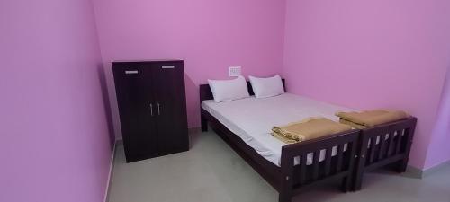 ein kleines Schlafzimmer mit einem Bett und einem Schrank in der Unterkunft STAYMAKER Madhu Residency in Sāgar