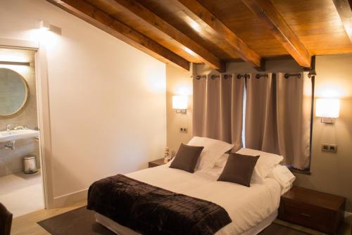 a bedroom with a large bed and a bathroom at Osabarena Hotela in Orozko