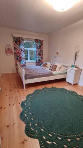 um quarto com uma cama e um tapete verde em Mökki Kainula em Veteli