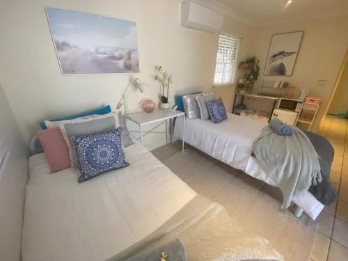 um quarto com 2 camas e almofadas em Cosy Haven For Females Only or Females & Child/ren em Brisbane