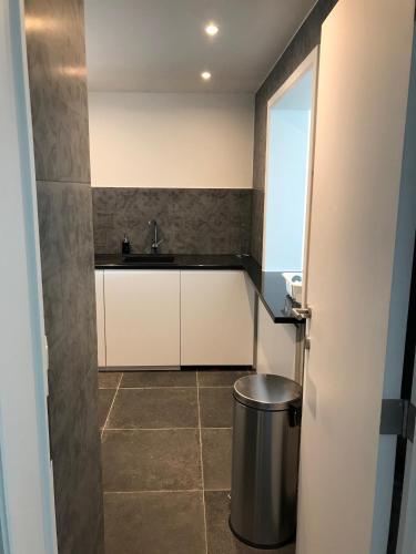 a small kitchen with a sink and a trash can at Knokke Sea, Appartement Vue mer in Knokke-Heist